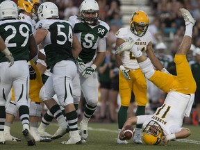 Alberta quarterback Brad Baker takes an upside-down tumble Friday night.