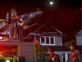 A near full moon illuminates Saskatoon Firefighters as they respond to a house fire on the 700 block of Stonebridge Commons in Saskatoon, Sask. on Tuesday, Sept. 5, 2017.