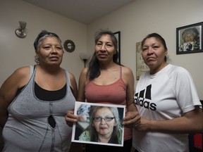 Lucy Moosewaypayo, Mercedes Whitehead and Stacey Moosewaypayo hold a picture of their deceased relative who was struck on her mobility scooter Friday afternoon in Saskatoon, Sask. on Saturday, September 9, 2017.