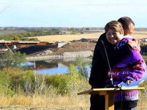 Shirley Isbister, President of Central Urban Metis Federation Inc., receives a hug from Gilles Dorval, the City of Saskatoon's director of Aboriginal relations, at a media event for the Naming the North Commuter Parkway Bridge (NCP) project at the North Commuter Parkway Viewing Area in Saskatoon on Sept. 20, 2017.