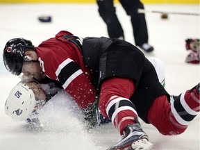 New Jersey Devils defenseman Damon Severson, top, fights with Vancouver Canucks center Brendan Gaunce during the first period of an NHL hockey game, Tuesday, Dec. 6, 2016, in Newark, N.J.