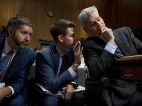 Sen. Bill Cassidy, R-La., right, speaks to an aide as he appears before a Senate Finance Committee hearing to consider the Graham-Cassidy healthcare proposal, on Capitol Hill, Monday, Sept. 25, 2017, in Washington. (AP Photo/Andrew Harnik)