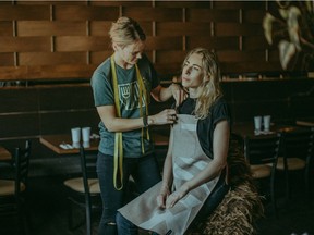 Designer Laurie Brown adjust an apron she created for chef Christie Peters for the Prairie Grid Dinner Series, which stops in Saskatoon on Oct. 3.