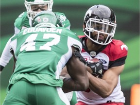Samuel Eguavoen, left, and the Saskatchewan Roughriders' defence held the Calgary Stampeders without a touchdown on Sunday.