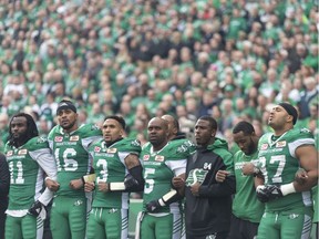 REGINA, SASK : Saskatchewan Roughriders quarterback Kevin Glenn (5) links arms with teammates during the Canadian National Anthem during a CFL game held at Mosaic Stadium on September 24, 2017. MICHAEL BELL / Regina Leader-Post. Michael Bell, Regina Leader-Post