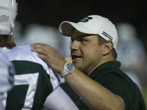 Huskies' defensive co-ordinator Warren Muzika talks to a player during the team's season opener.