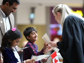 Zahid Rauf smiles as he and his children Hajira Zahid and Muhammad Rehan receive their Canadian citizenship certificates at Lawson Heights Mall in Saskatoon on October 17, 2017. (Michelle Berg / Saskatoon StarPhoenix)