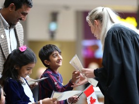 Zahid Rauf smiles as he and his children Hajira Zahid and Muhammad Rehan receive their Canadian citizenship certificates at Lawson Heights Mall in Saskatoon on October 17, 2017.