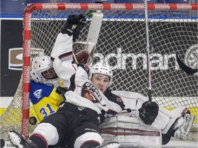 Vancouver Giants forward Brendan Semchuk crashing into the net and Saskatoon Blades goalie Ryan Kubic during second period WHL action at SaskTel Centre in Saskatoon.