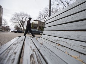 A pedestrian walks past a worn down city park bench in downtown, Saskatoon, SK on Thursday, October 26, 2017. (Saskatoon StarPhoenix/Kayle Neis)