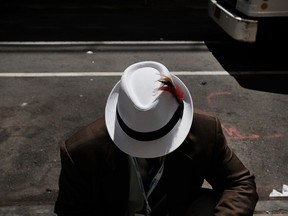 A street salesman sits on the sidewalk in New York City.