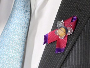 NDP MP Charlie Angus wears a pin honouring Sheridan Hookimaw, 13, who committed suicide on the Attawapiskat First Nation, as he speaks in the foyer of the House of Commons on Parliament Hill in Ottawa on Tuesday, May 10, 2016. The family of a teenager who killed herself in a remote Indigenous community on James Bay is calling for a coroner's inquest into her death two years ago, which sparked a crisis that garnered international attention and political promises of change.