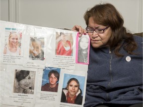 Dianne Big Eagle places her cheek next to a photo of her daughter Danita, one of many people who have gone missing in Saskatchewan.