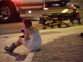 A woman sits on a curb at the scene of a shooting outside of a music festival along the Las Vegas Strip, Monday, Oct. 2, 2017, in Las Vegas. Multiple victims were being transported to hospitals after a shooting late Sunday at a music festival on the Las Vegas Strip. (AP Photo/John Locher) ORG XMIT: NVJL216
John Locher, AP