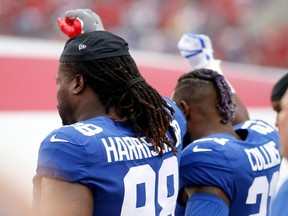 Defensive tackle Damon Harrison and strong safety Landon Collins of the New York Giants lock arms and raise their right fists into the air during the playing of the national anthem before the start of an NFL football game in Tampa, Florida on Oct. 1. 2017.