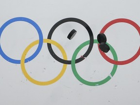 In this Feb. 22, 2014 file photo, pucks bounce off the boards in warm-up before the Sochi Olympic men's hockey bronze-medal game between the United States and Finland.