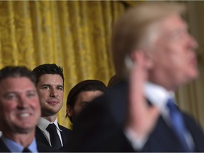 Pittsburgh Penguins captain Sidney Crosby, third from left, listens as President Donald Trump, right, speaks about the 2017 NHL Stanley Cup Champion Pittsburg Penguins, Tuesday, Oct. 10, 2017, during a ceremony in the East Room of the White House in Washington. (AP Photo/Susan Walsh)