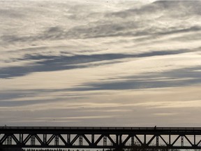 A person is small compared to the sky over the train bridge in Saskatoon, Thursday, Oct. 13, 2016.