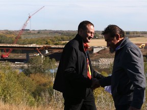 Gilles Dorval shakes hands with Harry Lafond, executive director, Office of the Treaty Commissioner, during the Naming the North Commuter Parkway Bridge (NCP) project media event at the North Commuter Parkway Viewing Area in Saskatoon on Sept. 20, 2017.