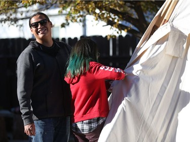 Ace Lafond helps his daughter Tala Lafond set up a teepee in their backyard.