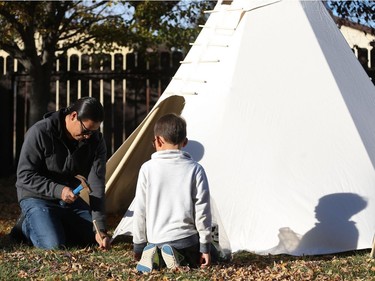 Ace Lafond teaches his youngest son Lex Lafond how to build a teepee in their backyard.