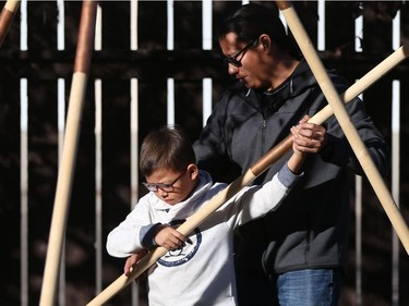 Ace Lafond and his youngest son Lex Lafond build a teepee in their backyard.