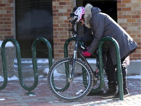 Cathy Watts, Saskatoon Cycles co-chair, locks up her bike before heading in to City Hall to speak to the transportation committee about the downtown bike lanes demonstration project in Saskatoon on Nov. 6, 2017.