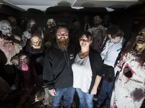 Adam Krutko, left, and Lyndsey Fernets stand in their home surrounded by various props that are used in a annual haunted house in Saskatoon, Sask. on Wednesday, November 8, 2017.