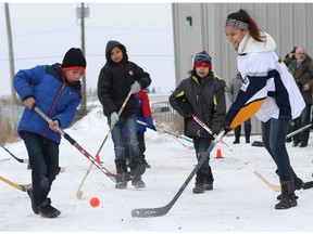 Lawrence Ochuschayoo (left) and Janessa Kahpoonapit from Yellow Quill First Nation play hockey with the new sticks donated to them. The Saskatoon Equipment Drive Committee, under KidSport Saskatoon, present an estimated $400,000 worth of sports equipment to members of the Big Island Lake Cree Nation and Yellow Quill First Nation at the Canadian Tire Warehouse in Saskatoon on November 16, 2017.