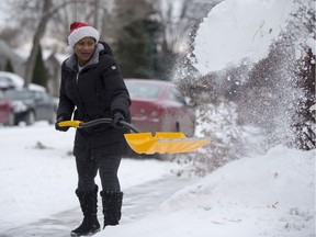 Isatu Kamara shovels snow off the sidewalk in front of her home on Middleton Crescent in Saskatoon on Friday, November 17, 2017.