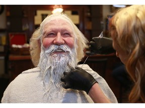 Santa Claus (name withheld to protect believers) gets his beard bleached by Chantal Chapman at Bourbon Barbershop in preparation for the Christmas season in Saskatoon on Nov. 9, 2017.