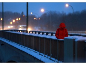 A morning commuter blocked her face from the chilly air during their walk to work before sunrise in Saskatoon on Nov. 20, 2017.