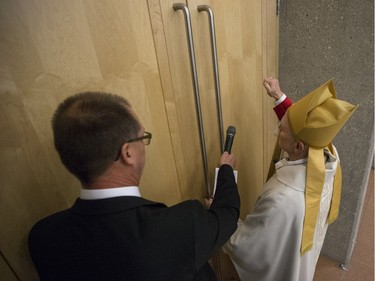 Most Rev. Mark Hagemoen, right, knocks on a door prior to his installation as Bishop of the Saskatoon Roman Catholic diocese at the Cathedral of the Holy Family in Saskatoon, on Thursday, November 23, 2017.