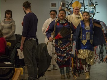 Most Rev. Mark Hagemoen, center, enters the Cathedral of the Holy Family church preceded by fancy dancer Sasha Stone, right, and jingle dancer Layla Stone prior to his installation as Bishop of the Saskatoon Roman Catholic diocese in Saskatoon, on Thursday, November 23, 2017.