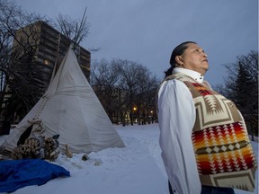 Alvin Baptiste stands near a teepee on Spadina Crescent containing a sacred fire that has been burning for the duration of the the National Inquiry into Missing and Murdered Indigenous Women and Girls hearings in Saskatoon, SK on Thursday, November 23, 2017. Baptiste is a fire keeper, one of a group of eight people who have watched over the fire. (Saskatoon StarPhoenix/Liam Richards)