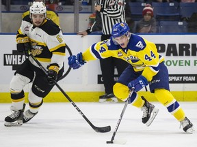 Saskatoon Blades forward Chase Wouters fights for the puck against Brandon Wheat Kings defender Schael Higson during the game at SaskTel Centre in Saskatoon on Friday, November 24, 2017.