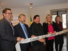 Saskatchewan's Minister of Social Services, Paul Merriman, left, alongside Don Windels, executive director of the Lighthouse Supported Living Inc., affordable housing complex project manager, Desmond Desnomie, City Councillor Bev Dubois and Kim Tyndall, an affordable housing consultant with the Canada Mortgage and Housing Corporation, participate in a ribbon cutting at the official opening of a seven-person capacity affordable housing complex in Saskatoon on Nov. 24, 2017. (Morgan Modjeski/The Saskatoon StarPhoenix) (Morgan Modjeski/The Saskatoon StarPhoenix)