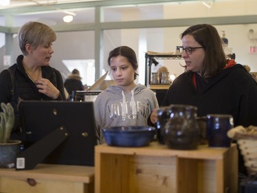 Misha Reiter, centre, looks at different pottery pieces for sale during the Saskatoon Potters Guild annual Christmas sale at the Albert Community Centre in Saskatoon on Saturday, November 25, 2017.