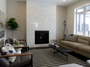 A cozy fireplace with modern white tile surround, plus oversized windows that frame a south-facing backyard create a main living area that is as beautiful as it is functional.