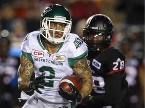 Saskatchewan Roughriders' Chad Owens, left, runs the ball past Calgary Stampeders' Brandon Smith during first half CFL football action in Calgary, Friday, Oct. 20, 2017. Owens returns to Toronto on Sunday eager to return to the Grey Cup, not earn redemption.