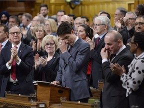 Prime Minister Justin Trudeau wipes his eye while he is applauded while making a formal apology to individuals harmed by federal legislation, policies, and practices that led to the oppression of and discrimination against LGBTQ2 people in Canada, in the House of Commons in Ottawa, Tuesday, Nov. 28, 2017.