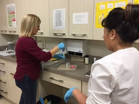 Nurse practitioner Pamela Komonoski (left) and Alice Gieb, a medical office assistant at the University of Saskatchewan's Student Wellness Centre, prepare a urine sample for testing as the university attempts to break the unofficial world record for most people to submit a urine sample in 10 consecutive hours to be tested for sexually transmitted infections on Nov. 1, 2017.