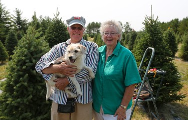 Bob Mason and Cora Greer, pictured in July with their dog Kayser, have been selling Christmas trees from their farm near Kenaston since 1998.