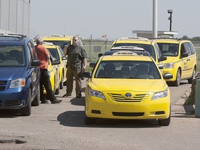 The City of Saskatoon is seeking input from residents on the future of the taxi industry and ride-sharing networks through an online survey. Taxis wait at the Saskatoon airport in this July 2013 photo. (GREG PENDER/The StarPhoenix)