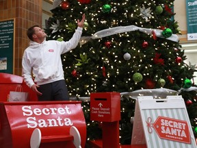 Mayor Charlie Clark flicks the switch, lighting up the Christmas tree in City Hall, and makes the first donation of a gift to launch the Secret Santa campaign in Saskatoon on Nov. 14, 2017.