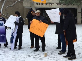 Members of the United Steelworkers Local 2014 and the Steelworkers Taxi Council rally outside Saskatoon City Hall to protest the introduction of ride-hailing apps like Uber and Lyft to the city on December 5, 2017.