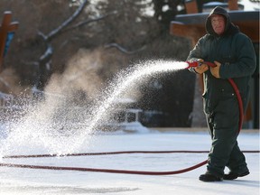 A man waters the Cameco Meewasin Skating Rink, getting it ready for the public to enjoy free skating in Saskatoon on December 6, 2017.