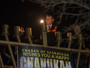 Mayor Charlie Clark ignites the first light to mark the start of Chanukah, the Festival of Lights at the Saskatoon Farmers Market in Saskatoon on Dec. 12, 2017.