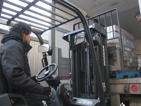 Warehouse assistant Kyle Lumberjack maneuvers pallets packed with a donation of frozen chickens at the Saskatoon Foodbank and Learning Centre on Wednesday Dec. 13, 2017.