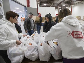 Volunteers help with the distribution of food as part of the Secret Santa Foundation annual event, where over 800 families are welcomed to their warehouse where toys, books and nutritious food hampers are given for the holidays, in Saskatoon, on Wednesday, December 20, 2017.